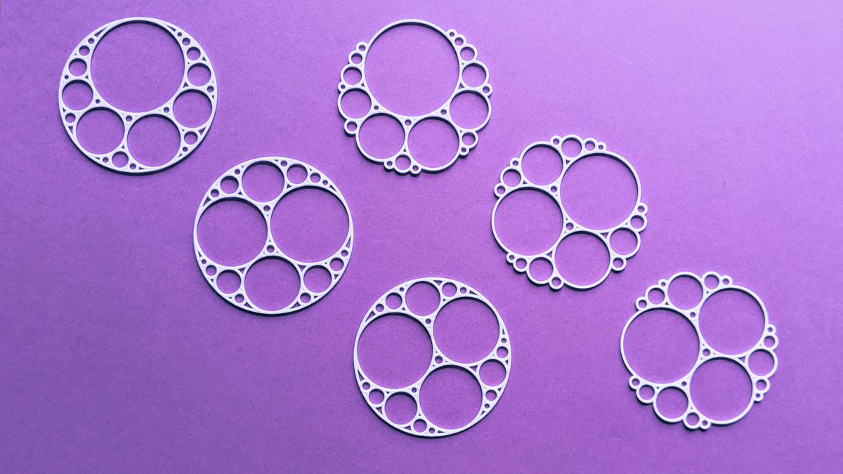 Six 3D-printed white Apollonian circle packing pendants on a purple background. The three on the left have a solid outer circle, and the three on the right have no outer circle, so their small circles form a bumpy edge.