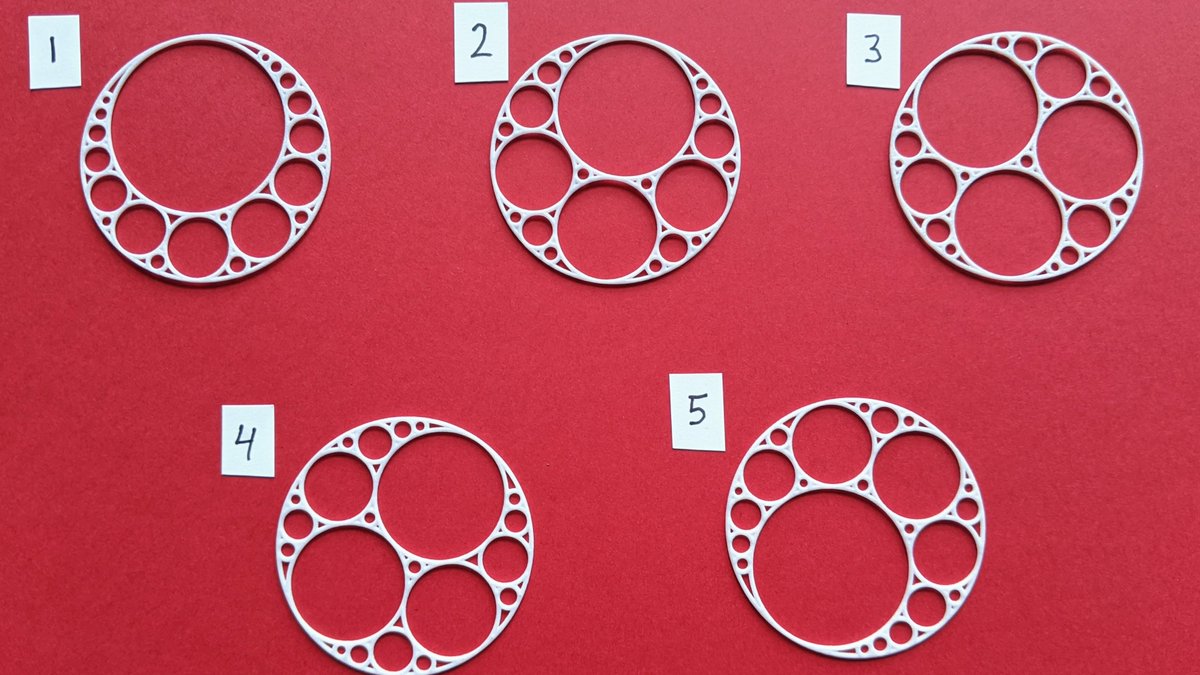 Five white Apollonian circle packing pendants on a red background, labeled 1 through 5, each generated from different random starting circles